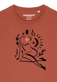 Roodbruine t-shirt, van biologisch katoen, met zwarte lijntekening van een zittende figuur met een hart, sterren en bloemaccenten.