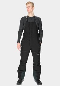 Black waterproof ski bib with adjustable straps, front zipper pocket, side pockets, and green accent panels at the cuffs.