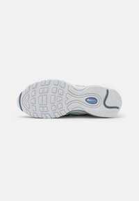 Semelle blanche de basket avec un motif de bande de roulement et un détail ovale bleu près de la voûte plantaire, présenté sur un fond gris clair uni.