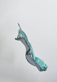 Leinenschal in Petrol und Grau mit abstrakten Designs. Leichtgewichtig, mit einem strukturierten Rand und in einer unregelmäßigen, fließenden Form.