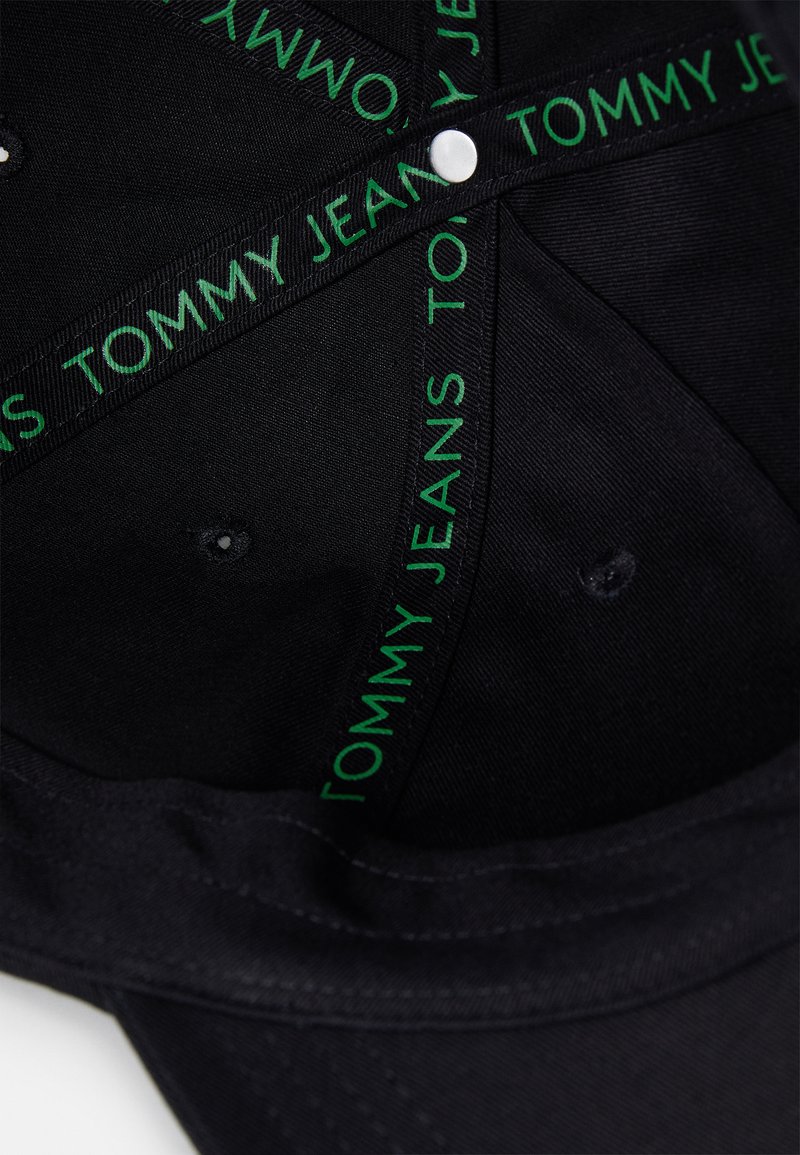 Czarna czapka z zielonym logo "TOMMY JEANS" na wewnętrznej opasce, wykonana z teksturowanego materiału z zapięciem na zatrzask i otworami wentylacyjnymi.
