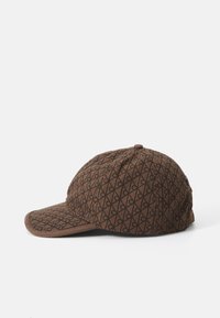 Brown cap with a textured fabric featuring a diamond pattern in black. Curved brim with a solid brown accent. Rear button detail.