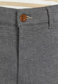 Pantaloni in tessuto grigio intrecciato con chiusura a bottone color nocciola, design con fronte piatto e discreto motivo testurizzato. Cuciture rinforzate lungo le cuciture.