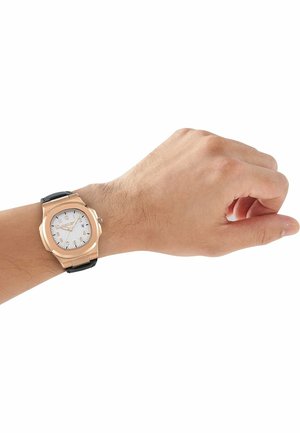 Linkerpols met een roségouden horloge met een witte wijzerplaat en een zwarte leren band, wijzend op 2:36.