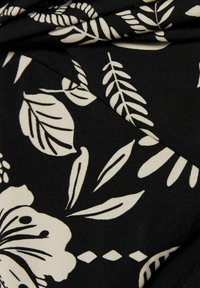 Material negru cu un model floral și frunze crema, cu contururi bine definite. Textura pare netedă și ușor elastică.