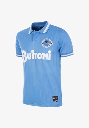 Polo bleu clair avec des rayures verticales, col blanc et bord des manches, logo "Buitoni" en évidence, et un écusson circulaire représentant le visage de Maradona.