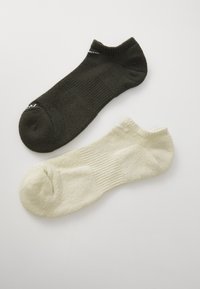 Schwarze und cremefarbene Knöchelsocken mit geripptem Bündchen und subtiler Textur, vor einem hellen Hintergrund präsentiert.