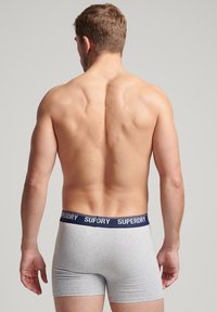 Grijze boxershorts met een marineblauwe tailleband met het "SUPERDRY"-logo, een aansluitend design en een zachte, gladde textuur.