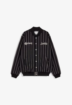 Schwarze Bomberjacke mit weißen vertikalen Streifen, Knopfverschluss vorne und besticktem Text "Grimen" und "Looters". Gerippte Bündchen und Saum.