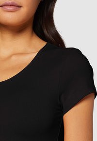 Top nero a maniche corte con scollatura rotonda, realizzato in un tessuto liscio e a coste. Presenta un design aderente e dettagli di cucitura minimi.