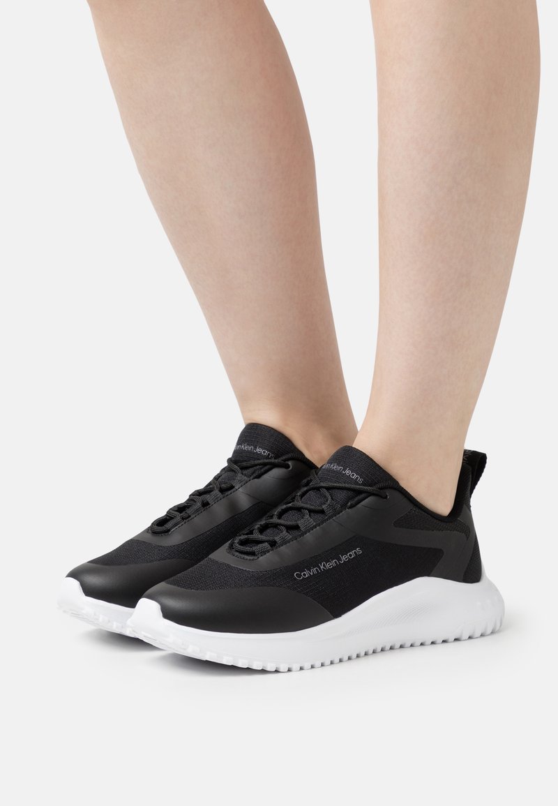Scarpe sportive nere dal design elegante, con tomaia opaca, tessuto testurizzato e suola in gomma bianca. Presente il marchio Calvin Klein Jeans.