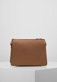 Borsa a mano in pelle marrone con una forma rettangolare strutturata, caratterizzata da una cerniera dorata e una tracolla arancione. Texture liscia, design minimale.