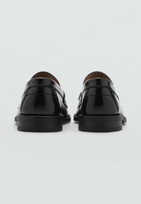 Black patent leather shoes with a sleek design, smooth texture, and a low, flat heel. No prominent accents or patterns visible.