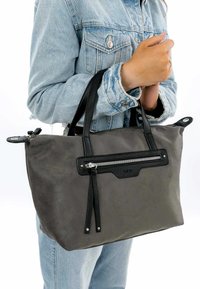 Graue Stoff-Handtasche mit schwarzen Lederakzenten, Reißverschlusstasche, zwei stabilen Griffen und einem minimalistischen Design. Verfügt über sichtbare Steppnähte.