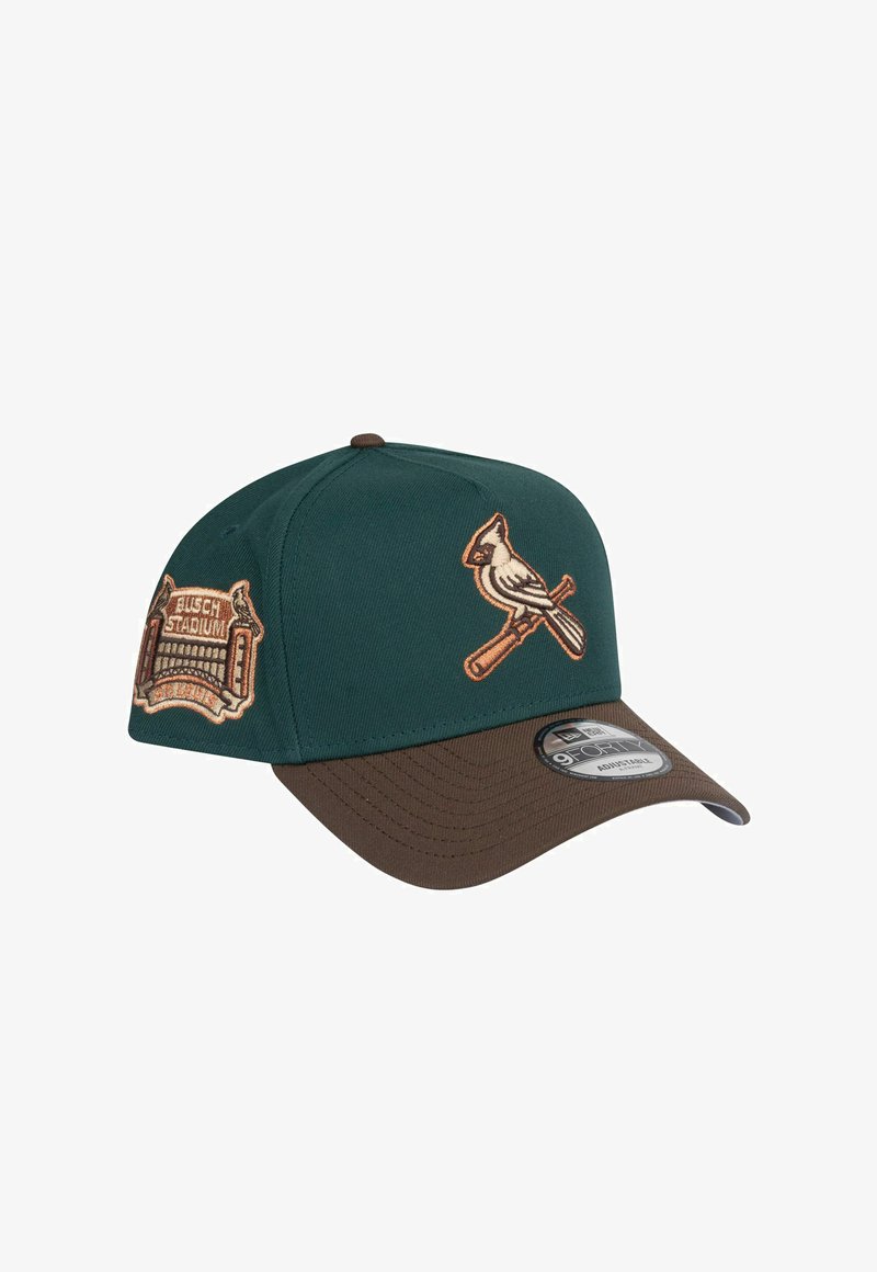 Casquette de baseball verte et marron avec un logo cardinal brodé et un patch "Busch Stadium". Présente un devant structuré et une visière courbée.