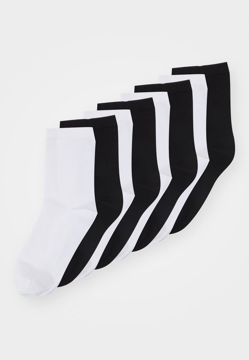 Fem par crew-sokker i sorte og hvide farver. Stoffet ser glat ud med et simpelt design og en ribbet manchet øverst.