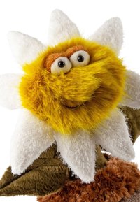 Yellow and white fuzzy flower puppet with large eyes and a smile, sitting on brown and green textured fabric.