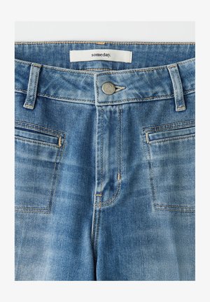 Hellblaue Jeans aus Denim mit glatter Textur, Fünf-Taschen-Design, sichtbaren Nähten und silberner Knopfverschluss. Das Etikett trägt die Aufschrift "someday".