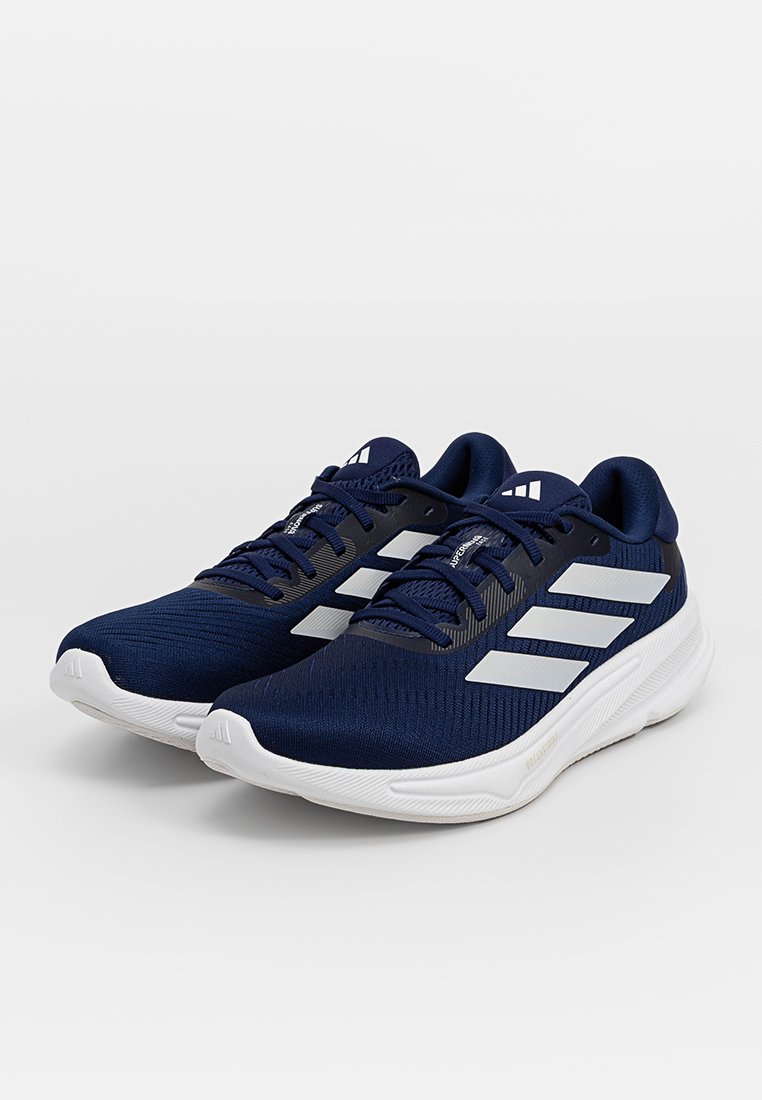Zapatillas deportivas marinas hechas de malla transpirable con acentos en blanco de tres rayas, cordones planos y una suela de goma blanca texturizada.