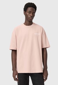 Ανοιχτό ροζ βαμβακερό T-shirt με άνετη εφαρμογή και κοντά μανίκια. Φέρει το λογότυπο «ALLSAINTS» τυπωμένο σε λευκό στην αριστερή πλευρά του στήθους.