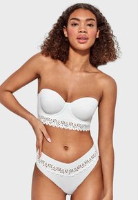 Bikini top bandeau blanco con ribete de encaje ondulado, copas acolchadas; parte inferior alta a juego con un detalle de encaje similar. Textura suave.