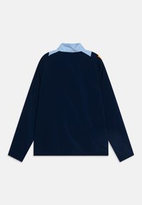 Giacca a vento navy con colletto e spalle azzurre chiare, dotata di maniche lunghe e di una texture del tessuto liscia e resistente.