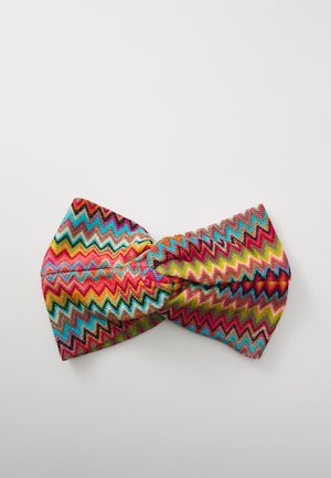 Flerfarget hodeband med et zigzag-mønster i rosa, blått, gult og grønt. Laget av et teksturert stoff med en knyttedetalj.