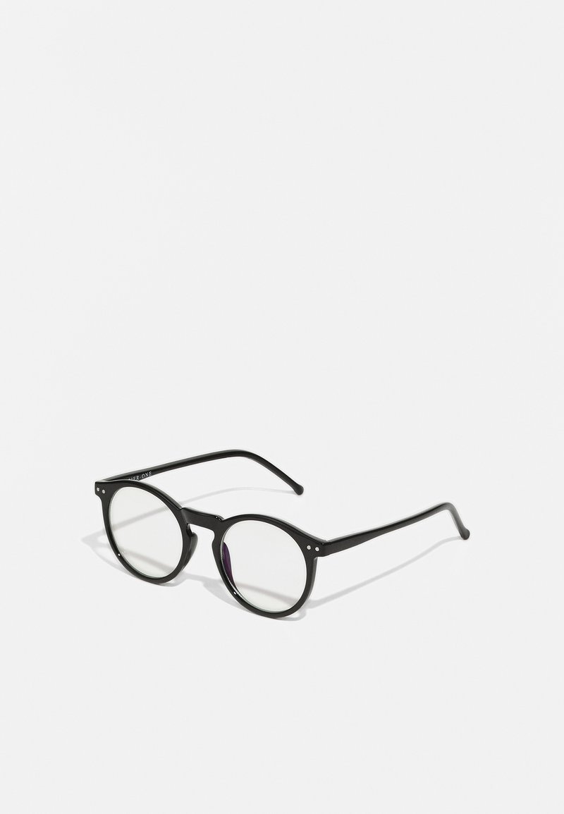 Gafas de sol redondas y negras con lentes transparentes, brazos delgados en negro y pequeños acentos metálicos en la parte frontal. Diseño clásico con estilo minimalista.