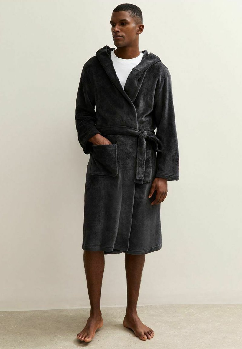 Grijze zachte badjas met capuchon, lange mouwen, strikceintuur en zakken. Gemaakt van pluche materiaal, knielang ontwerp, weergegeven op een staande figuur.