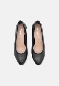 Paire de ballerines en cuir noir avec bouts arrondis, doublure intérieure douce, taille 37, et nom de la marque imprimé à l’intérieur de chaque chaussure.