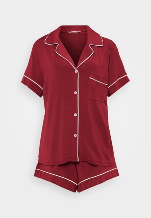 Κόκκινο σετ πυτζάμας κοντομάνικο από μαλακό ύφασμα, με λευκές λεπτομέρειες, που περιλαμβάνει πουκάμισο με κουμπιά και τσέπη και αντίστοιχες βερμούδες.