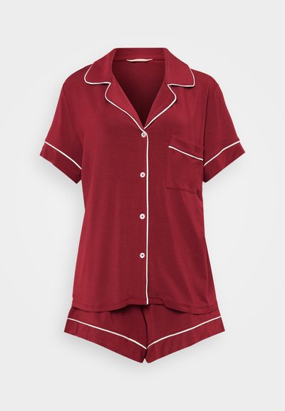 Conjunto de pijama curto de manga curta, em tecido suave, com detalhes em branco, uma camisa abotoada com um bolso de remendo e calções à condizer.