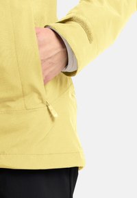 Geel waterdichte jas met een ritszak en een verstelbare klittenbandmanchet. Gladde textuur met een casual pasvorm.