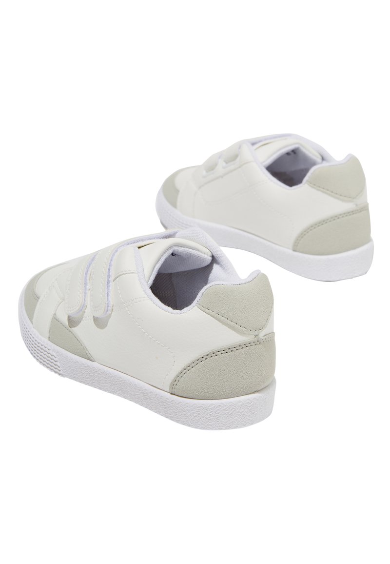 Baskets blanches avec une tige en cuir lisse, des accents gris, des bandes Velcro et une semelle en caoutchouc texturée. Bout arrondi et design bas.