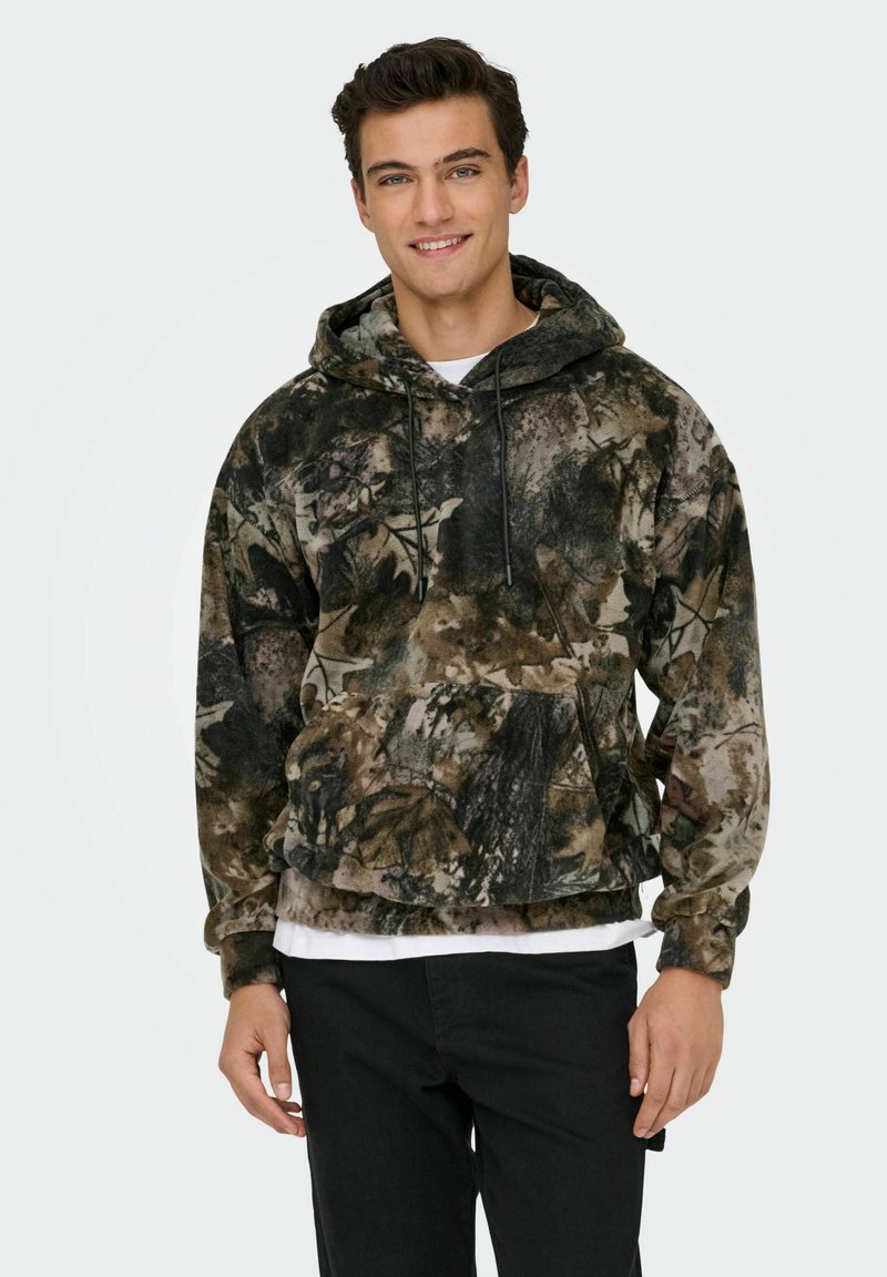 Sweat à capuche camouflage en teintes terre, avec une poche avant, des cordons de serrage réglables et une coupe décontractée. Texture douce et design chaud.
