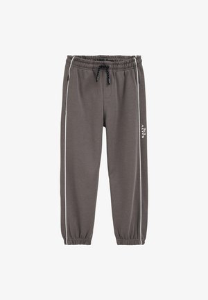 Pelēkas sporta bikses ar auklu viduklī, elastīgām aprocēm un baltām sānu svītrām. Vienā kājā ir raksts. Izgatavotas no mīksta, elastīga materiāla.