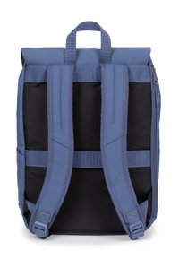 Blå och svart ryggsäck med rulltoppdesign, tygremmar, framficka och subtila sömnadsdetaljer. Har ett dragkedjestängning och ett robust handtag.