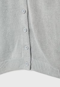Gray knitted cardigan featuring a button front closure with six light gray buttons and ribbed hem and cuffs for added texture.