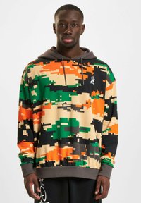Hooded sweatshirt featuring a pixelated camouflage pattern with green, orange, black, and beige colors; elastic cuffs and hem.