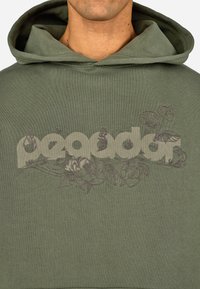 Felpa verde oliva con cordino. Presenta una grande grafica con il testo "peagdar" intrecciato con motivi floreali in un tenue colore marrone.