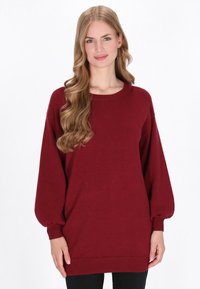 Bordeauxfarbener Oversize-Pullover mit langen, gepufften Ärmeln und rundem Halsausschnitt. Gerippte Bündchen und Saum. Weicher Textur und lässige Passform.