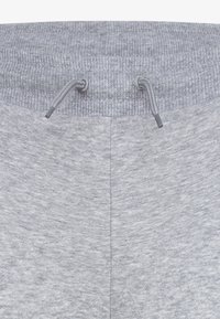 Grå joggebukser med ribbet linning og justerbare snordrag. Myk, teksturert stoff med heathered mønster.