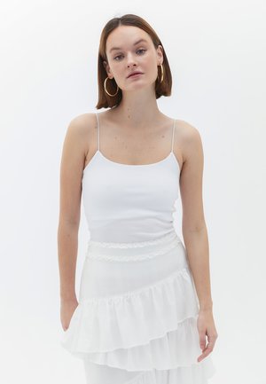Witte geribde tanktop met dunne bandjes, gecombineerd met een gelaagde witte rok met ruches, gemaakt van een gestructureerde stof en met een ruches tailleband.
