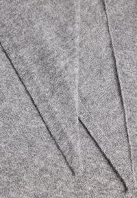 Harmaa neulepusero, jossa on rakenteellinen pinta, V-avoin kaula-aukko ja näkyvät saumat, sekä vaihtelevaa sävyä syvyyttä varten.