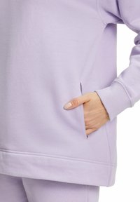 Oversized lavendel sweatshirt met een ronde halslijn, geribde manchetten en een zijzak. Zacht katoenmix materiaal met een gladde textuur.