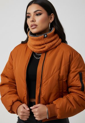 Orange puffer jacket with quilted design, ribbed cuffs, and a chunky knitted orange and gray neck warmer featuring a logo detail.