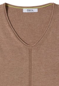 Vêtement tricoté marron avec encolure en V et détail de couture centrale visible, avec une étiquette "CECIL" cousue au col.