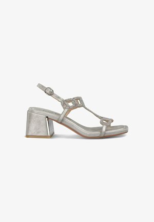 Sandalias plateadas con tacón cuadrado, que presentan una tira en T adornada con acentos de strass y una correa ajustable en el tobillo.