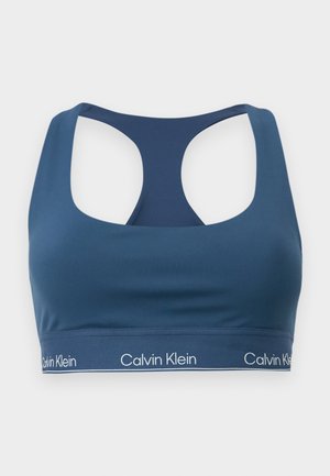 Marineblauwe sportbeha met een ronde hals, racerback ontwerp en contrasterend wit Calvin Klein-logo op de elastische band. Gladde textuur.