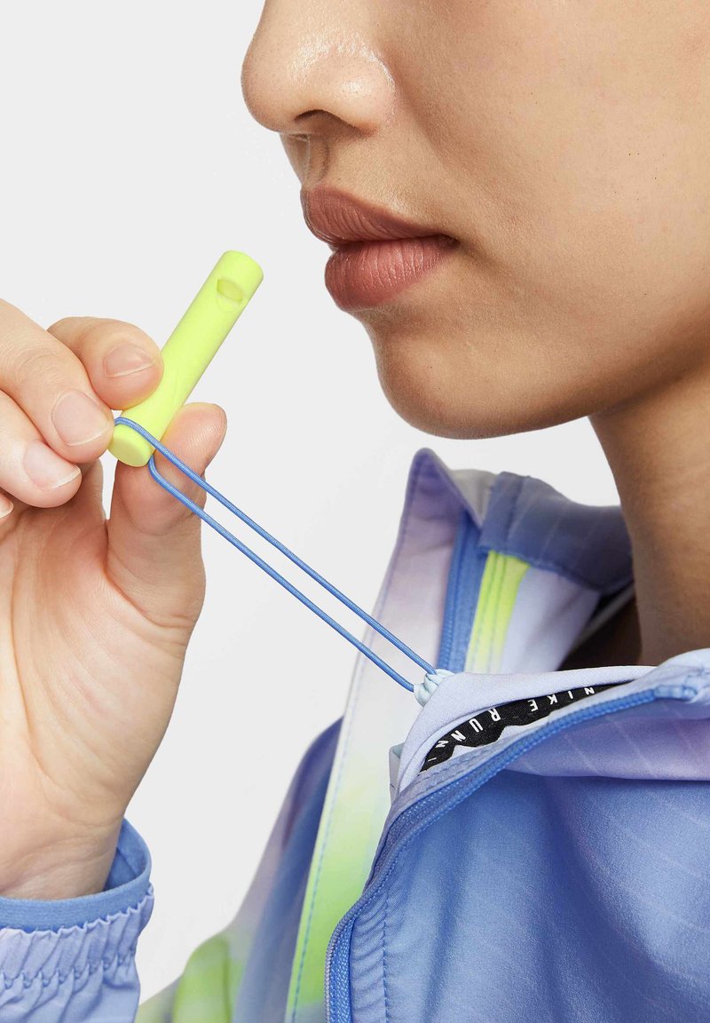 Een lichtblauwe jas met een trekkoordsluiting, voorzien van neongele accenten en een blauwe koord, vastgehouden door een hand vlakbij de halslijn.